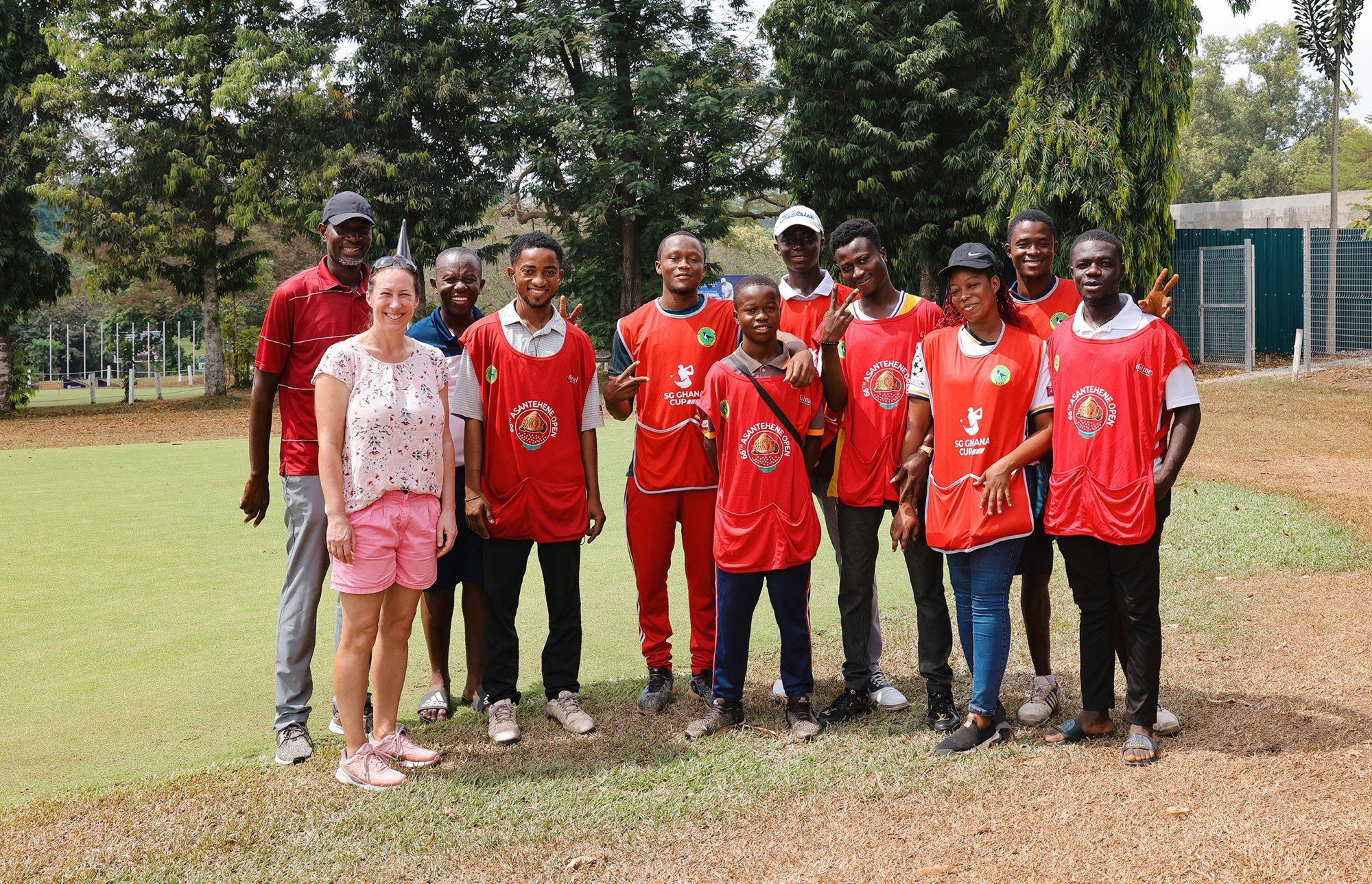 Inga Freitag mit Prof. Bernard K. Baiden und Caddies in roten Leibchen auf dem Platz des Royal Golf Club Kumasi